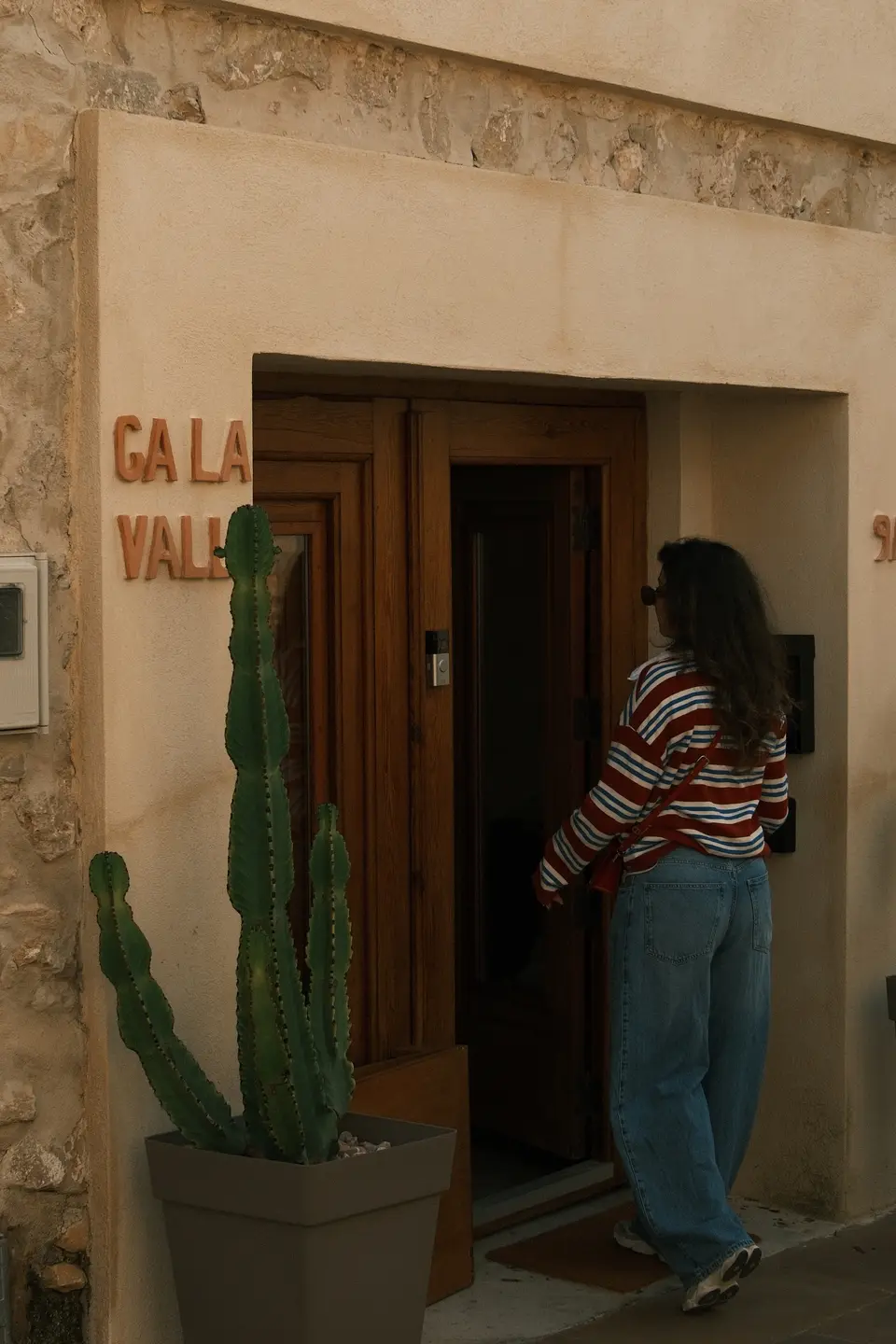 Nikki opent de deur van een stenen vakantiehuis in Lliber, een cactus in een pot naast de stoep